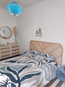 a bedroom with a bed with a tree patterned blanket at Cabine de la plage 2 in Fécamp