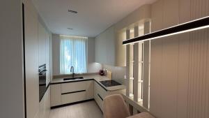 a kitchen with white cabinets and a sink and a window at RETLAV LUXURY Apartment in San Donato Milanese