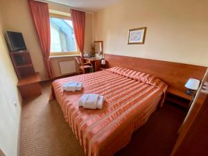 a hotel room with a bed with two towels on it at Hotel-Restaurant Smilga in Kėdainiai +48 photos