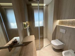 a bathroom with a toilet and a glass shower at RETLAV LUXURY Apartment in San Donato Milanese +15 photos
