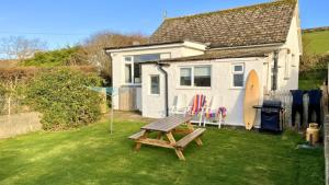 a picnic table in front of a tiny house at CROYDE SEAGRASS 2 Bedrooms in Croyde