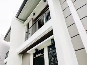 a white house with a door and a balcony at Lukali Staycation in Tagbilaran City