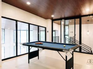 a pool table in a room with windows at Lukali Staycation in Tagbilaran City