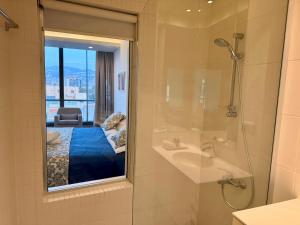 a bathroom with a shower and a bed and a mirror at Unit For Living in Beirut +31 photos