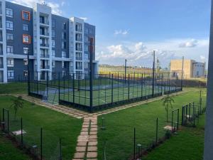 a tennis court in a park next to a building at Upendo Apartment 2 Bedroom in Tilisi in Gatimu