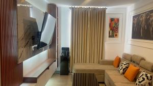 a living room with a couch and a flat screen tv at Upendo Apartment 2 Bedroom in Tilisi in Gatimu