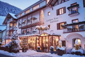 a hotel with christmas trees in front of it at Goldene Rose Karthaus a member of Small Luxury Hotels of the World in Senales