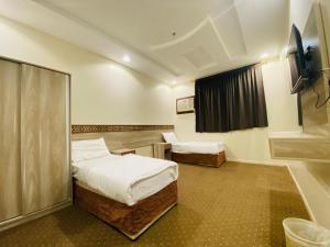 a small room with two beds and a window at Emaar million6 in Quai