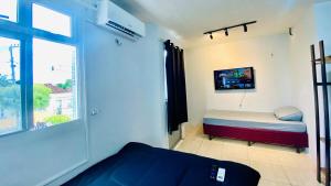 a small bedroom with a bed and a window at Ap com ar próximo ao centro in Crateús