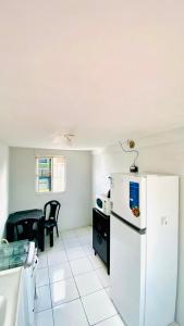 a kitchen with a white refrigerator and a table at Ap com ar próximo ao centro in Crateús