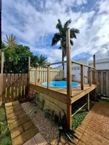 a wooden deck with a hot tub in a backyard at Cozy house with sea view! in Luquillo