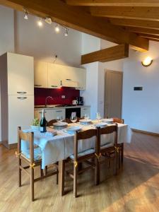a dining room with a table with chairs and a kitchen at Casa Sole in Vercana