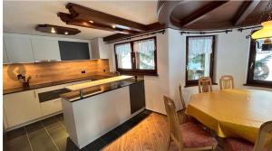 a kitchen and dining room with a table and a table and chairs at Chalet Sunstar in Saas-Grund