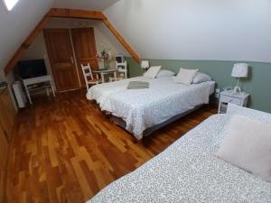 a bedroom with two beds and a couch in it at les alouettes in Leschelles