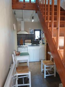 a kitchen with white cabinets and a staircase in a room at les alouettes in Leschelles
