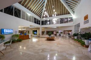 a large lobby with plants in a building at Viva Heavens by Wyndham, A Trademark All Inclusive in San Felipe de Puerto Plata +84 photos