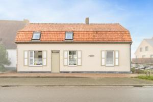a small white house with an orange roof at Het Rustplekje in Alveringem