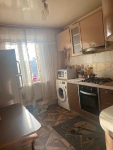 a kitchen with a stove and a washing machine at Апартаменты м Южне in Sychavka