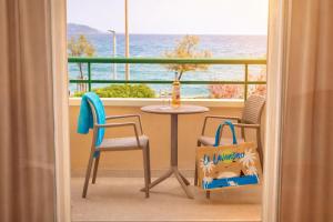 a balcony with a table and chairs and a view of the ocean at Résidence Kaliopé in Le Lavandou