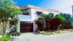 a house with a motorcycle parked in front of a gate at Beach Heaven Guest House in Karachi
