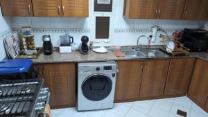 a kitchen with a washing machine and a sink at Elegant Double Room in Abu Dhabi