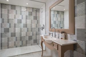a bathroom with a sink and a shower with a mirror at Domeniile Martinutzi - Hotel Cardinal in Alba Iulia +55 photos