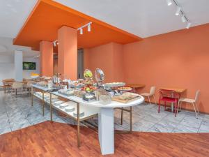 a room with a table with food on it at B&B HOTEL Milano Cologno Studios in Cologno Monzese +23 photos