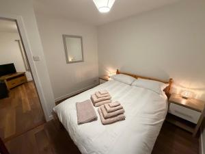 a bedroom with a white bed with towels on it at Sandyloch Flat in Lerwick