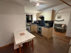 a kitchen with a table and a couch in a room at Sandyloch Flat in Lerwick