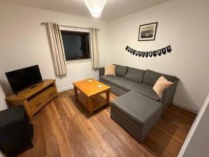 a living room with a couch and a television at Sandyloch Flat in Lerwick