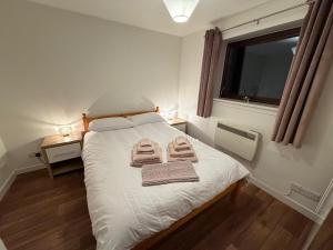 a bedroom with a bed with two towels on it at Sandyloch Flat in Lerwick