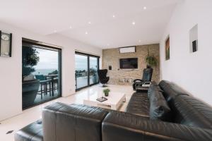 a living room with a brown leather couch at Senator Lux in Ulcinj