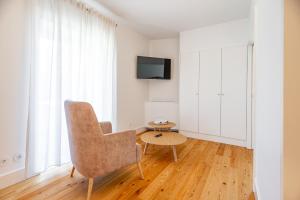 a living room with a chair and a table at Boutique Hotel Casa da Brêa Viana do Castelo in Viana do Castelo