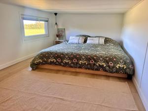 a bedroom with a bed and a window at Tiny House Cosy Climatisée in Saint-Sylvain-dʼAnjou