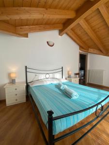 a large bed in a room with wooden ceilings at Casa Sole in Vercana