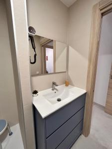 a bathroom with a sink and a mirror at One Apartamentos in Torreorgaz +28 photos