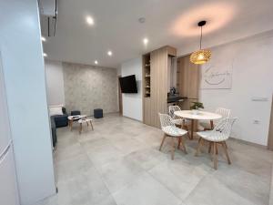 a dining room and living room with a table and chairs at One Apartamentos in Torreorgaz