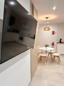 a kitchen and dining room with a table and chairs at One Apartamentos in Torreorgaz