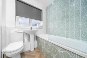 a bathroom with a tub and a toilet and a sink at 3-Bed Home in East Kilbride Ideal for Contractors & Longer Stays from Voyage Collection in East Kilbride +53 photos