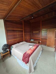 a bedroom with a large bed in a room with wooden walls at CASA DA MATA - LAVRAS NOVAS in Lavras Novas +16 photos