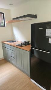 a kitchen with a black refrigerator and a sink at Abagta Kosan in Jakarta +2 photos