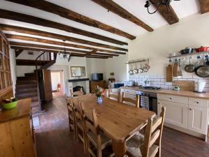 a large kitchen with a wooden table and chairs at Chez le Cavalier in Génis