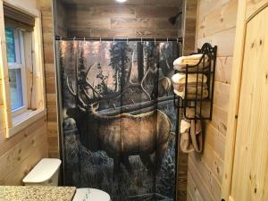 a shower curtain with a picture of a moose in a forest at Little Elk Cabin in Banner Elk +24 photos
