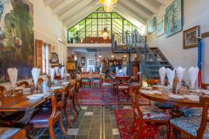 a restaurant with wooden tables and chairs and a staircase at Marrian George Hotel in Koringberg