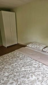 a bedroom with a large bed and a cabinet at Abagta Kosan in Jakarta