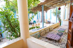 a patio with a table and chairs in a building at Aisha Guest House And Restaurant in Al Aqālitah