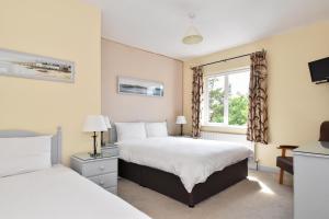 a bedroom with two beds and a window at Mannin Lodge in Ballyconneely