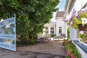a garden with a white gate and a table and chairs at Mannin Lodge in Ballyconneely