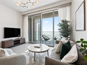 a living room with a couch and a tv at Exquisite 2BDR Retreat In Forte-33 in Dubai