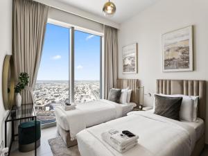 two beds in a hotel room with a large window at Exquisite 2BDR Retreat In Forte-33 in Dubai +22 photos